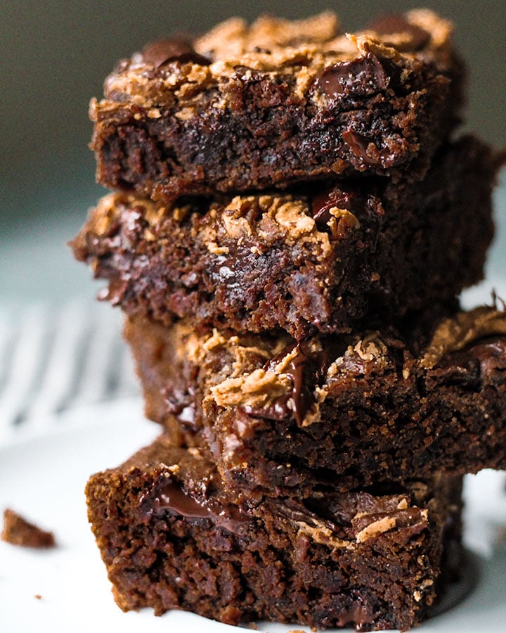 A closer shot of a stack of 4 fudgy black bean brownies on a plate.