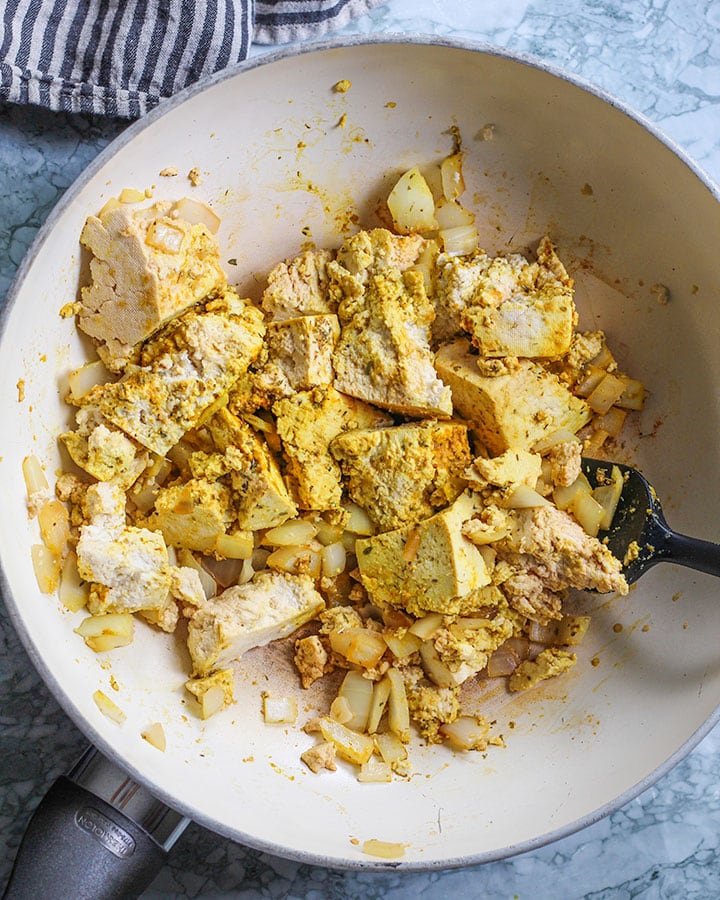 Tofu scramble in the making with tofu, onion and all dry seasonings mixed in.