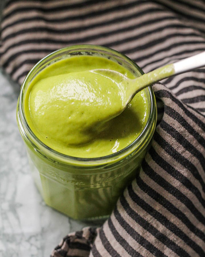 Green dressing in jar with spoon.