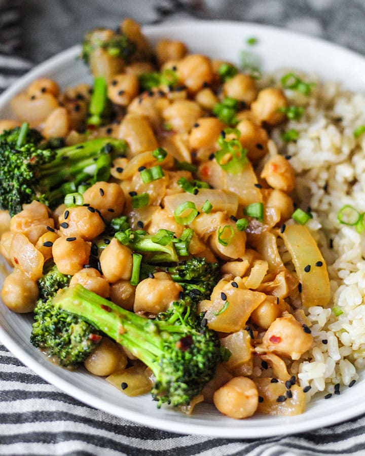 Angle view of peanut miso chickpeas and broccoli over a bed of rice.