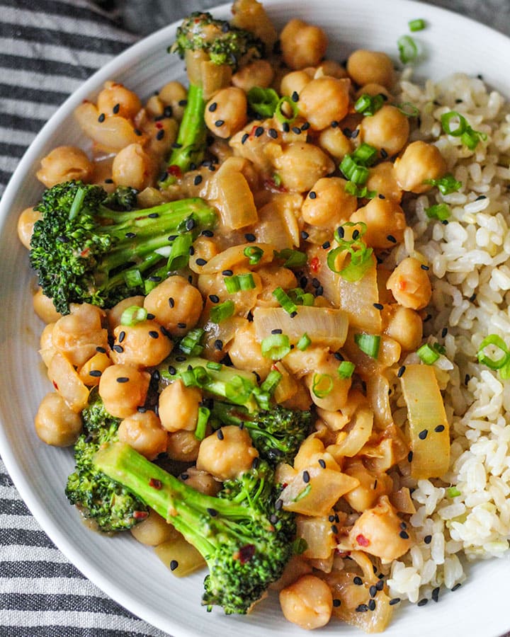 Flatlay shot of peanut miso chickpeas over rice. Close up shot of chickpeas.