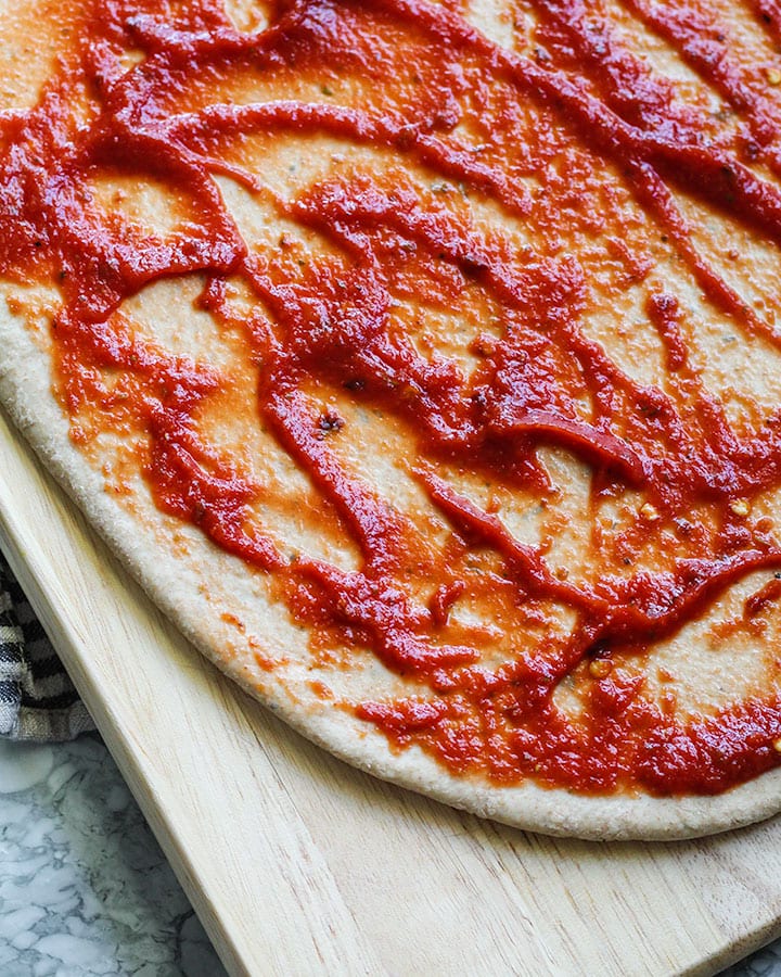 Pizza dough with homemade sauce.