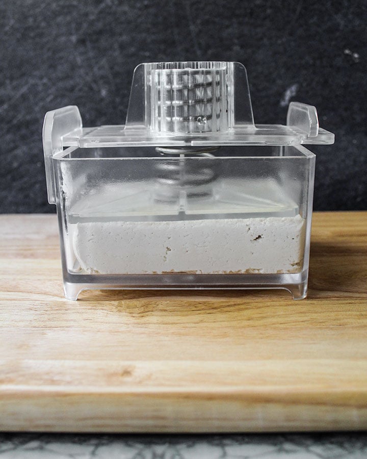 Block of tofu in a tofu press.