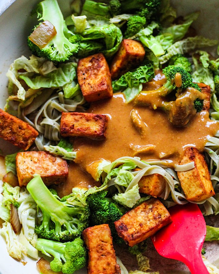 Noodles with cabbage, broccoli and tofu with peanut sauce poured on top.