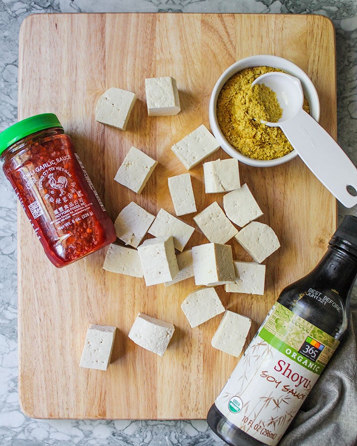 Tofu cut up and ready to marinate with soy sauce, garlic chili sauce and nutritional yeast.