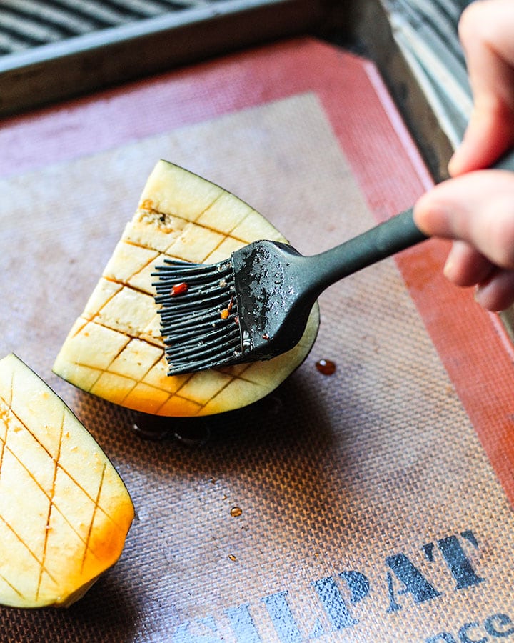 Basting eggplant pieces with spicy miso sauce.