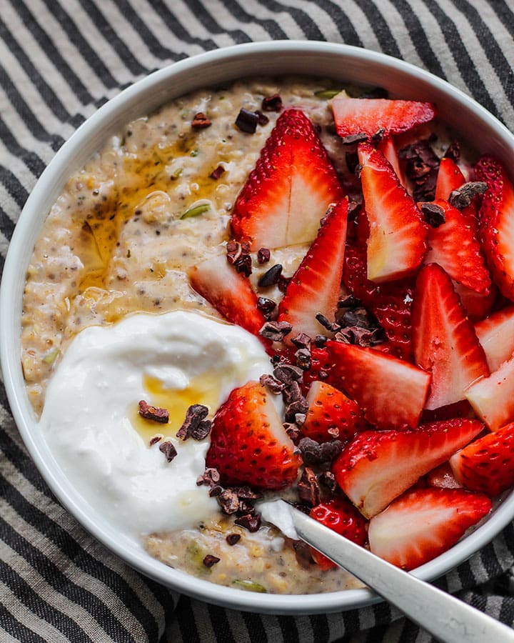 This creamy bowl of high protein strawberry oatmeal feels like spring in a bowl. It also is loaded with 19 grams of plant based protein to keep you full! Topped with fresh strawberries, it's the perfect vegan & gluten-free breakfast for everyone.