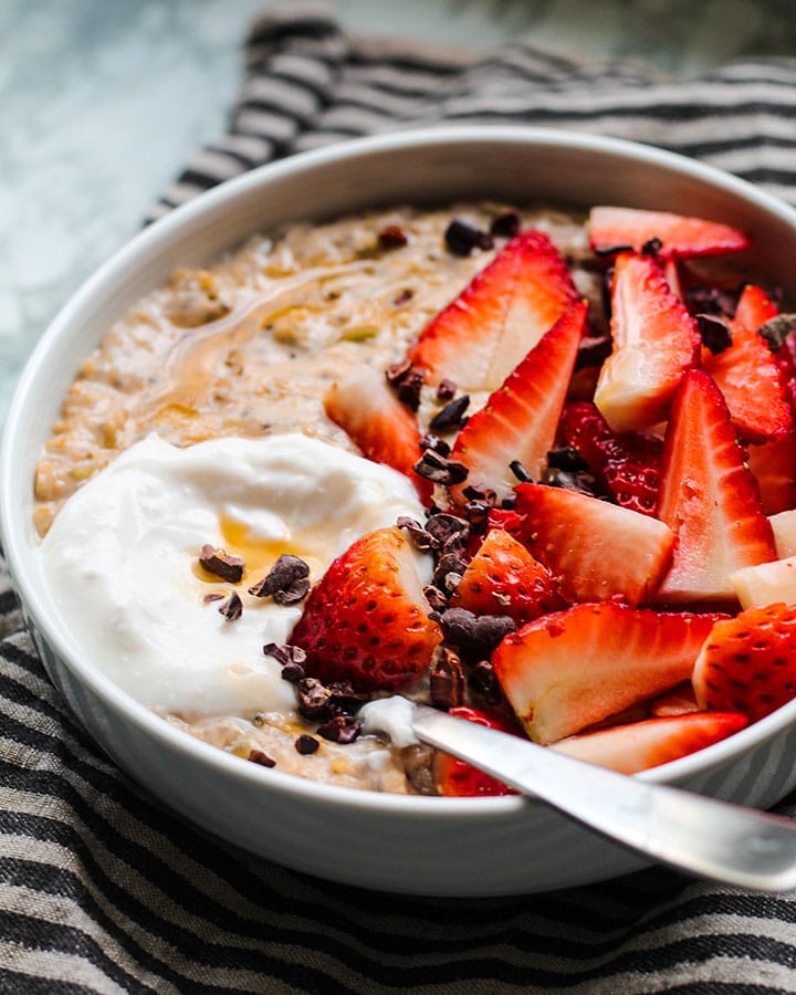 This creamy bowl of high protein strawberry oatmeal feels like spring in a bowl. It also is loaded with 19 grams of plant based protein to keep you full! Topped with fresh strawberries, it's the perfect vegan & gluten-free breakfast for everyone.