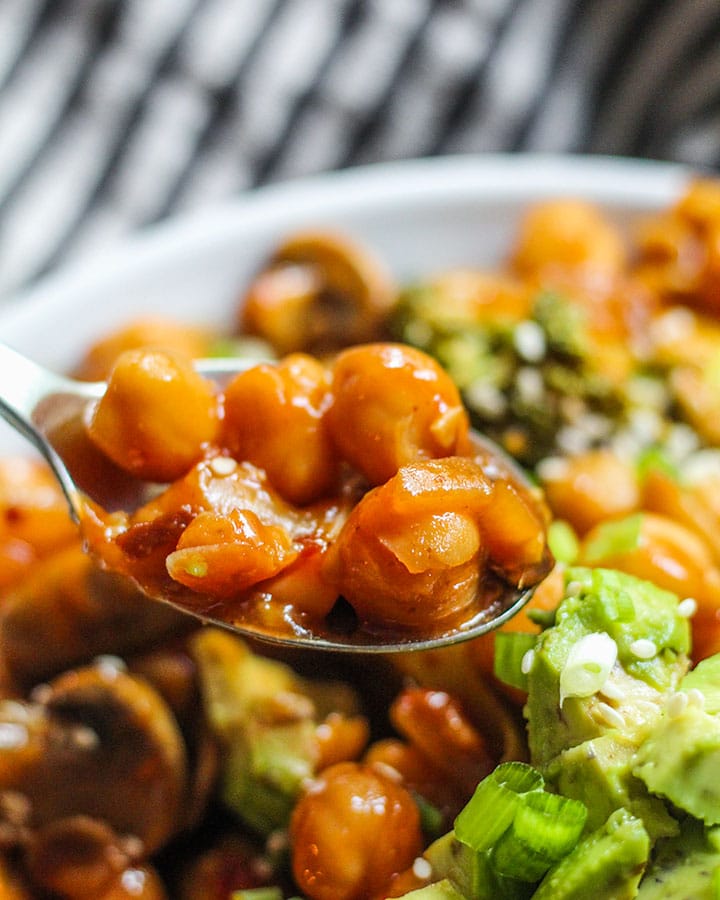 Close up of a spoonful of sweet and sour chickpeas.