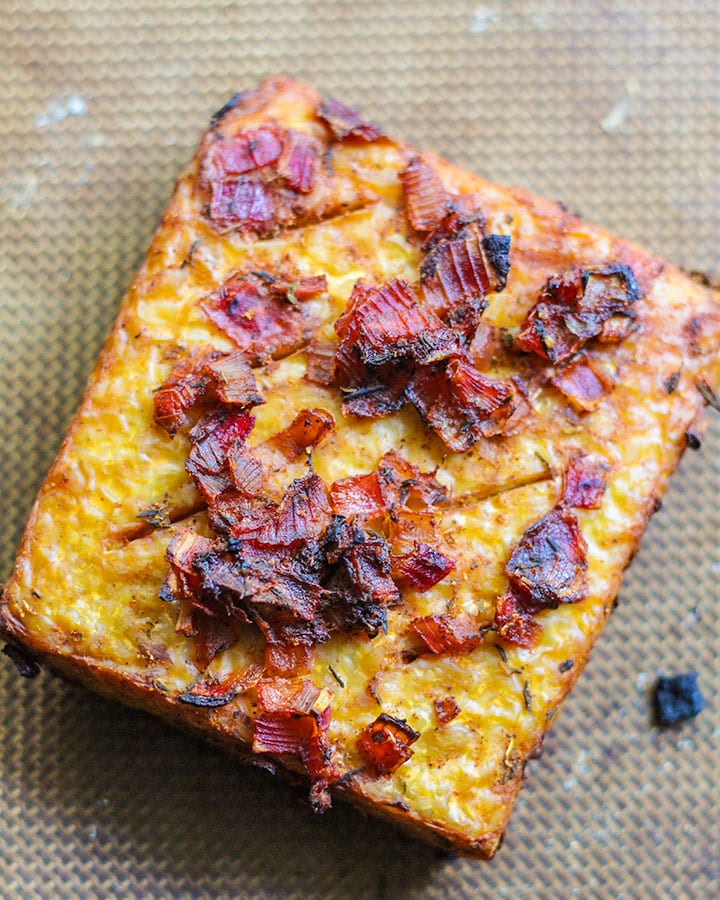 Baked tempeh topped with onions.