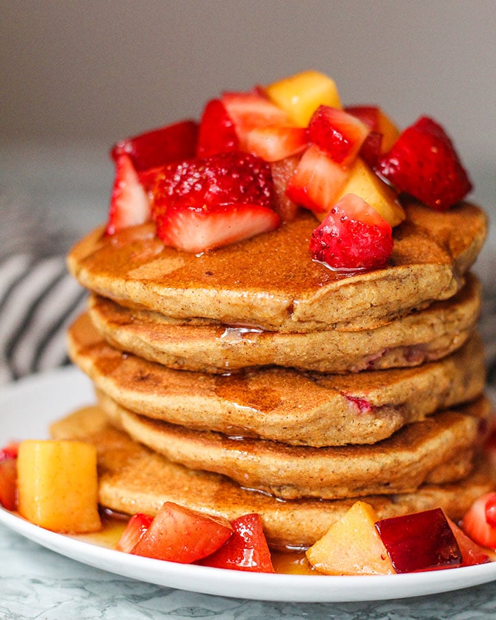 Cornmeal pancakes with strawberries folded in and stacked.