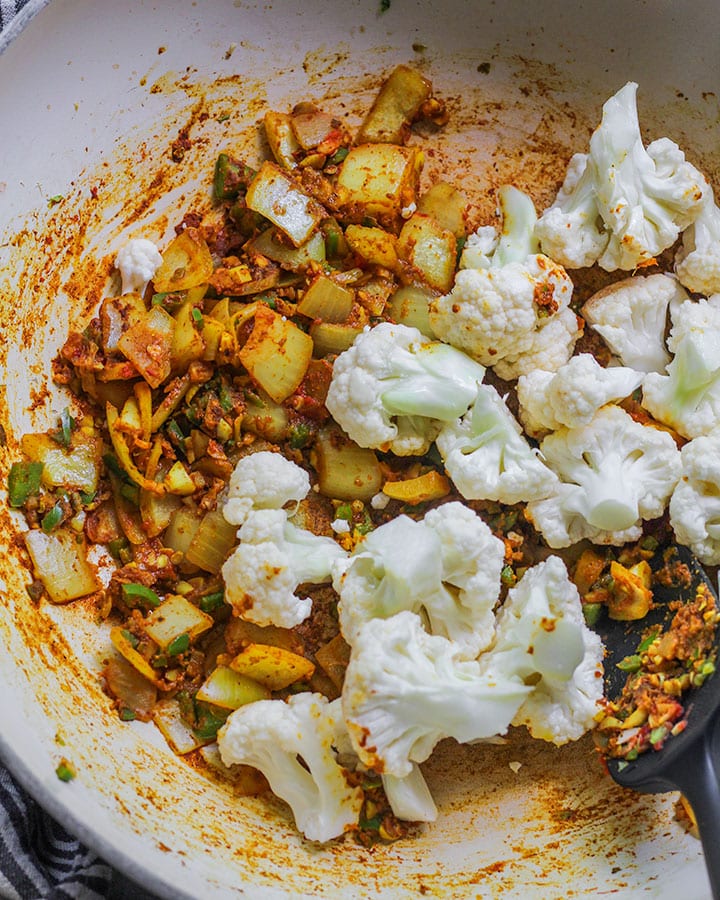 Cauliflower added to curry spices, onions and garlic and ginger.