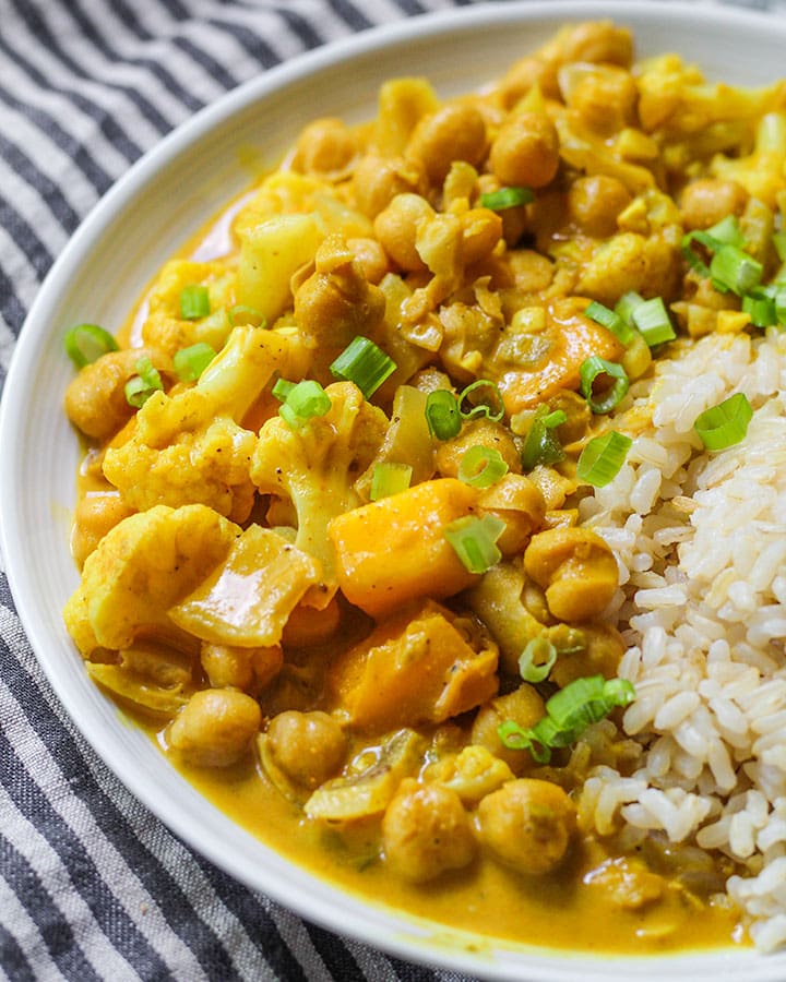 Side angle view of mango coconut chickpea curry in a bowl.