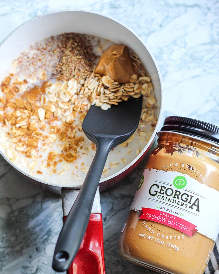 Oatmeal ingredients in sauce pan along with a jar of cashew butter.