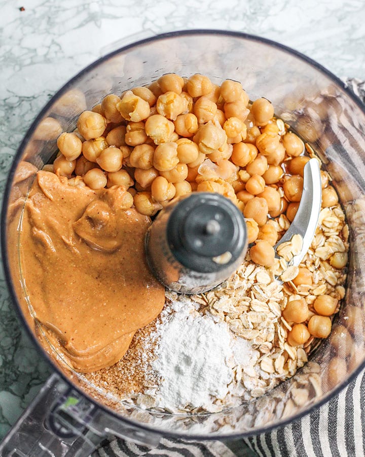 Chickpeas, oats, peanut butter and sugar ready to blend in a food processor.