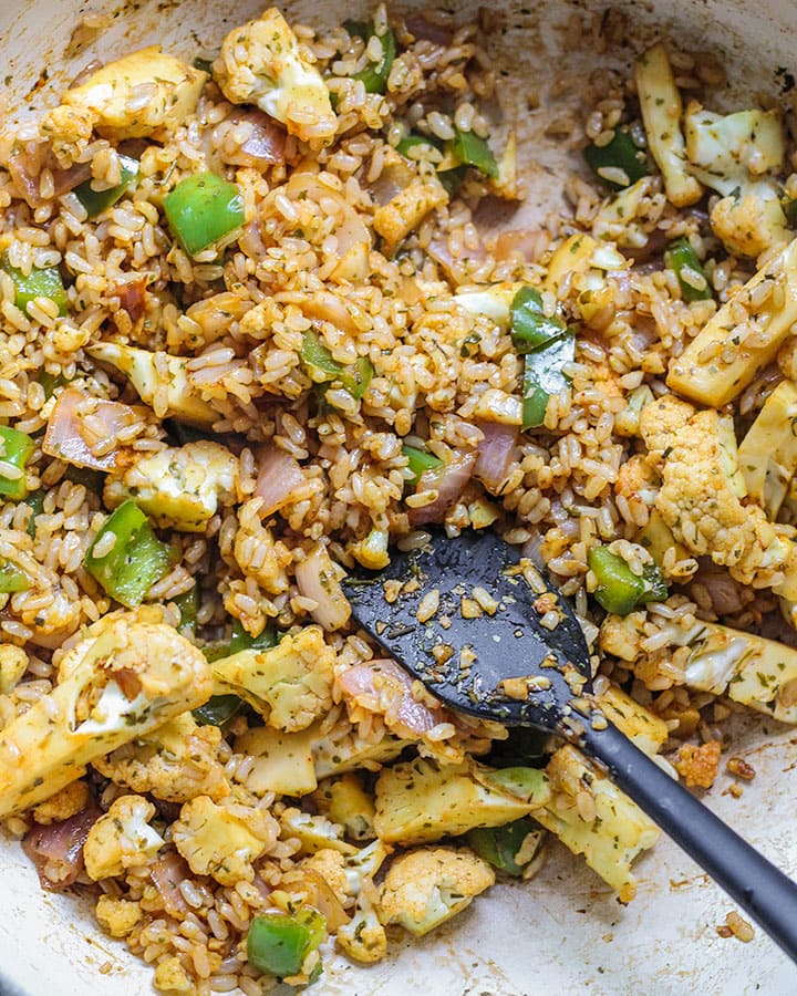 Rice mixed with soy sauce and vegetables in a pan.