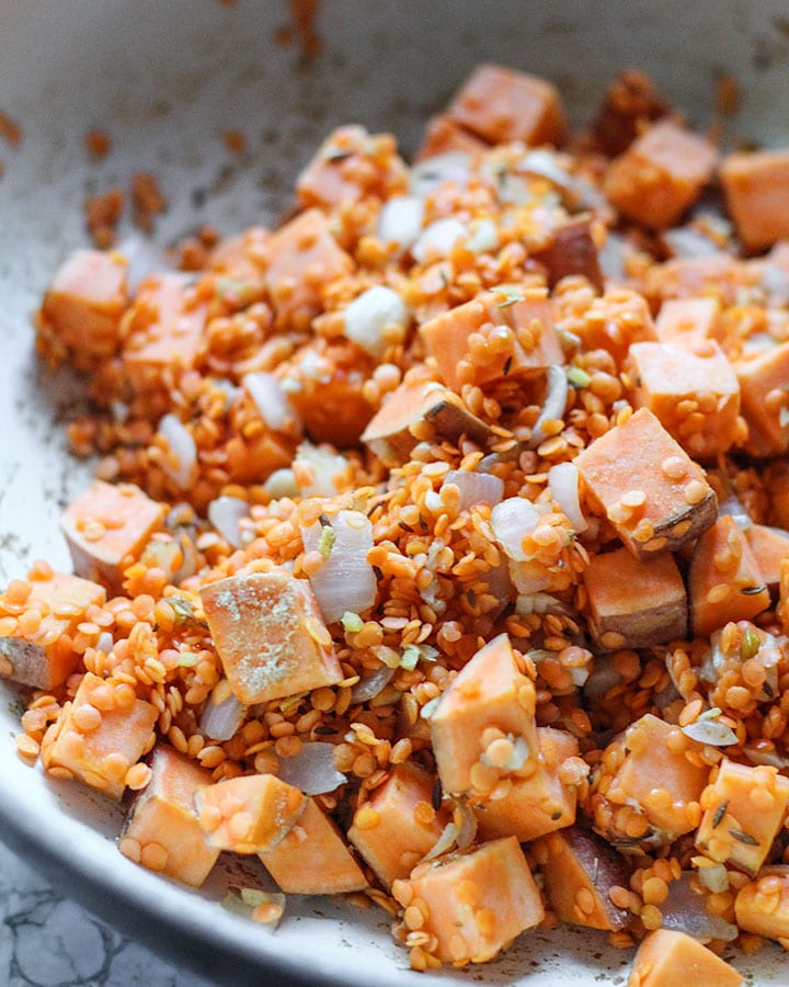Sweet potato and spices mixed in a pan.