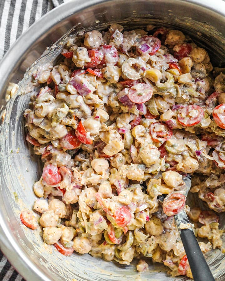 Chickpea salad ingredients all mixed together in mixing bowl.