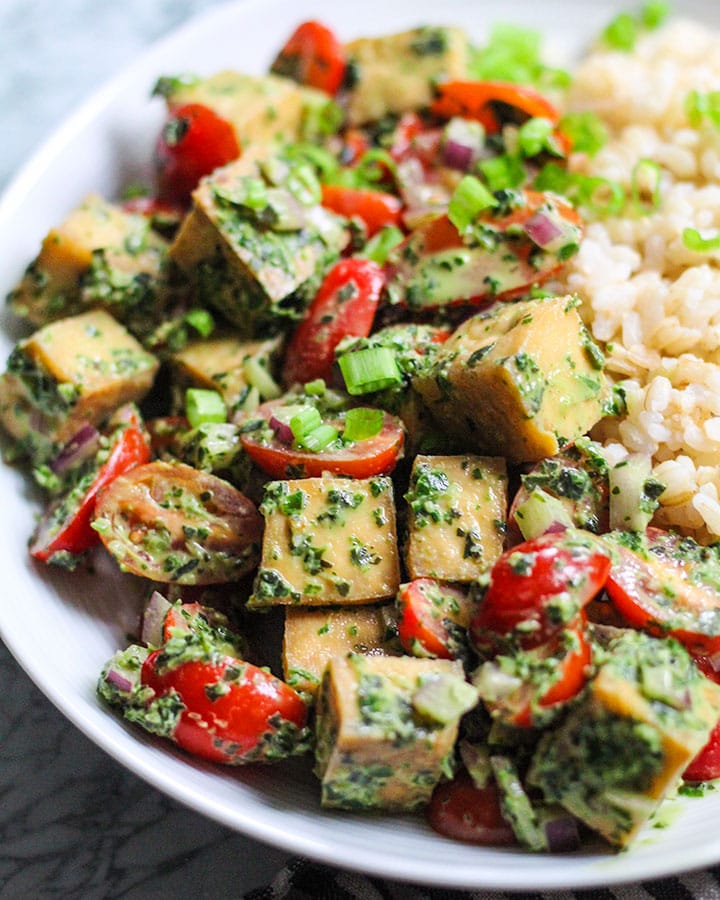 Plate with tofu salad with pesto and rice from the side.