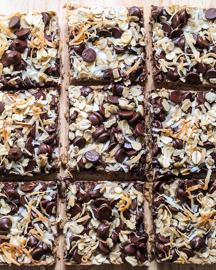 Top down view of magic bars topped with coconut, chocolate chips and oats.