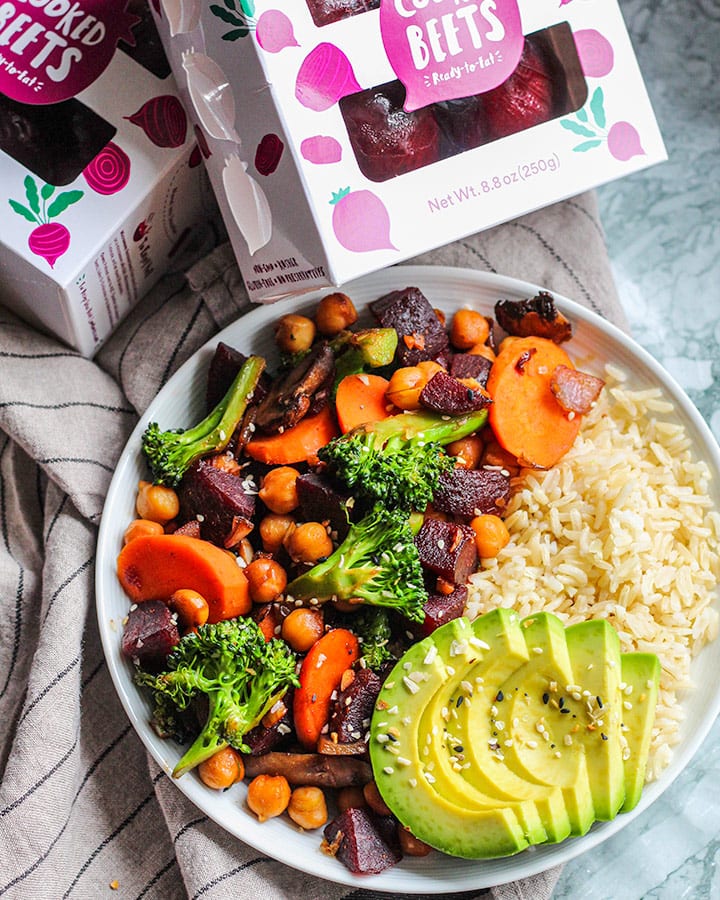 Bowl of stir fry with rice and avocado next to packages of pre cooked Love Beets.