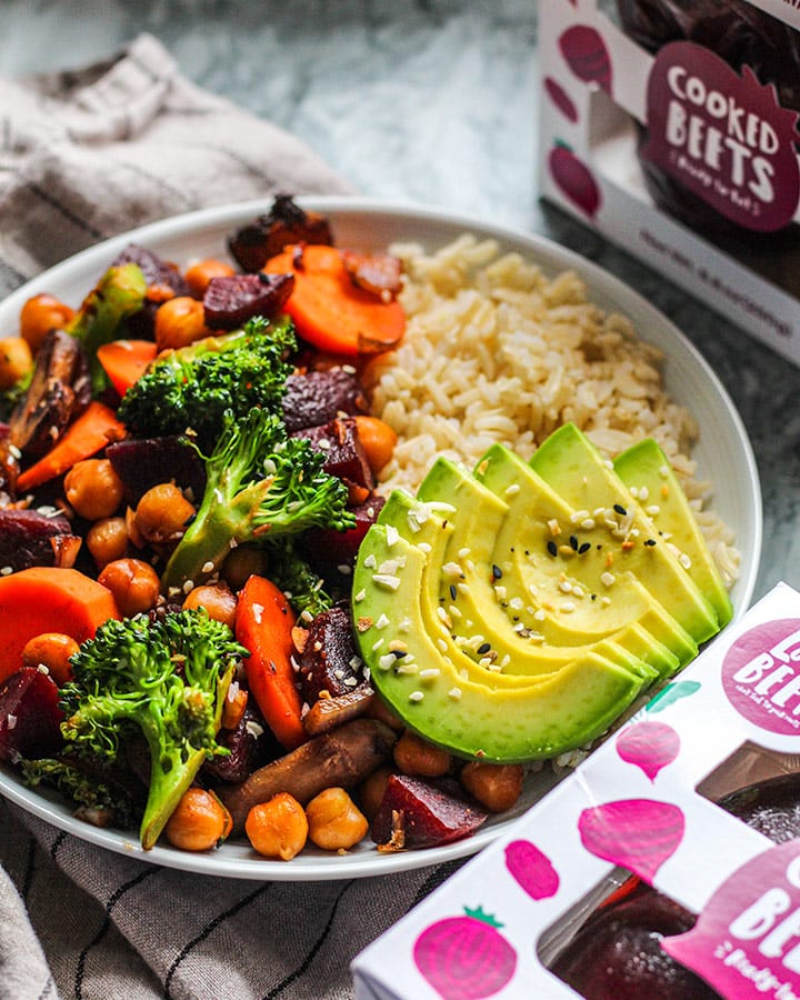 Stir fry vegetables including a mix of beets, broccoli, chickpeas and carrots paired with avocado and brown rice. 