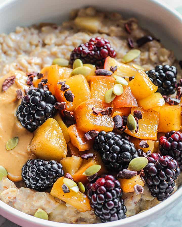 Close up of the oatmeal bowl with berries, apples, and peanut butter.