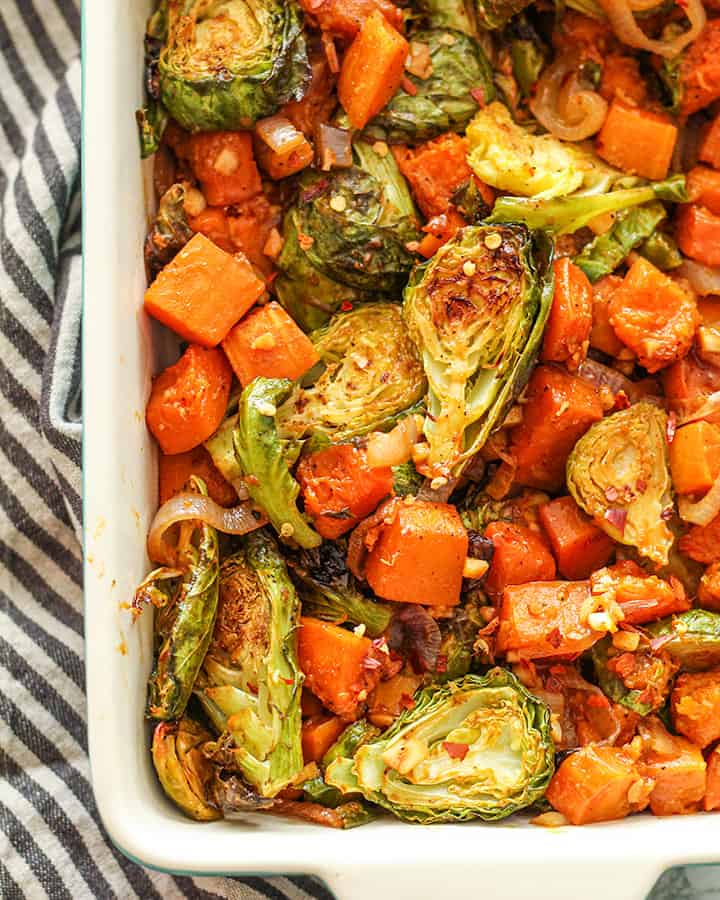 Roasted vegetables in a backing dish right out of the oven after being tossed in orange sauce.