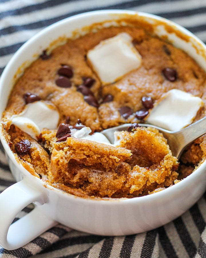 Scooping a spoon of pumpkin mug cake out of the cup.