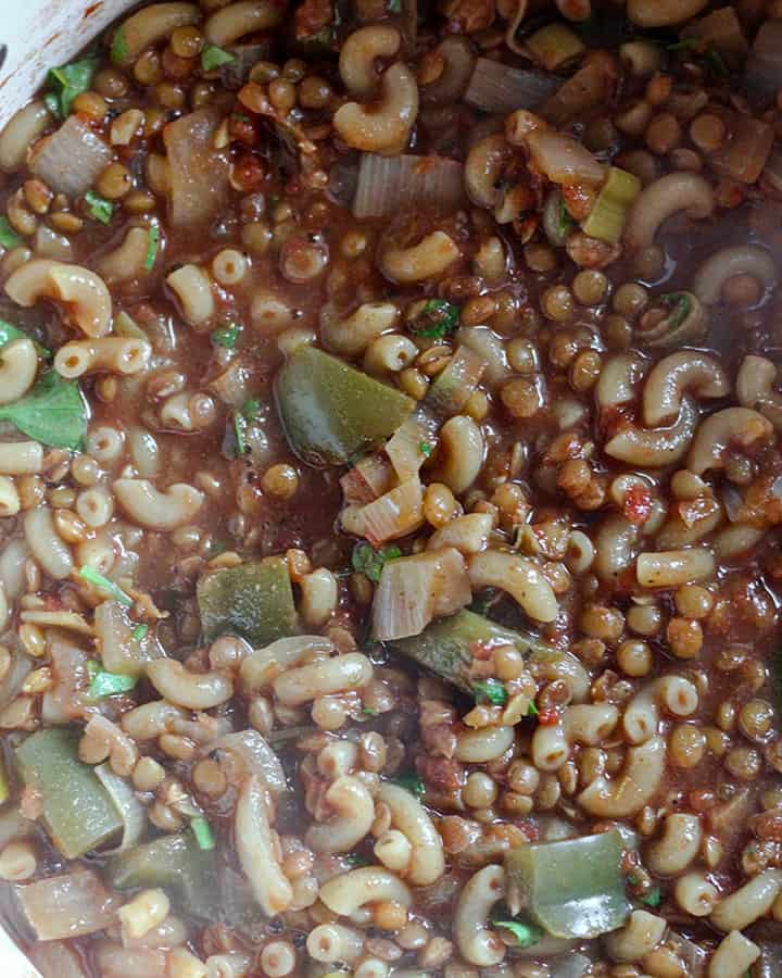 Lentils and macaroni all cooked together and simmering in pot.