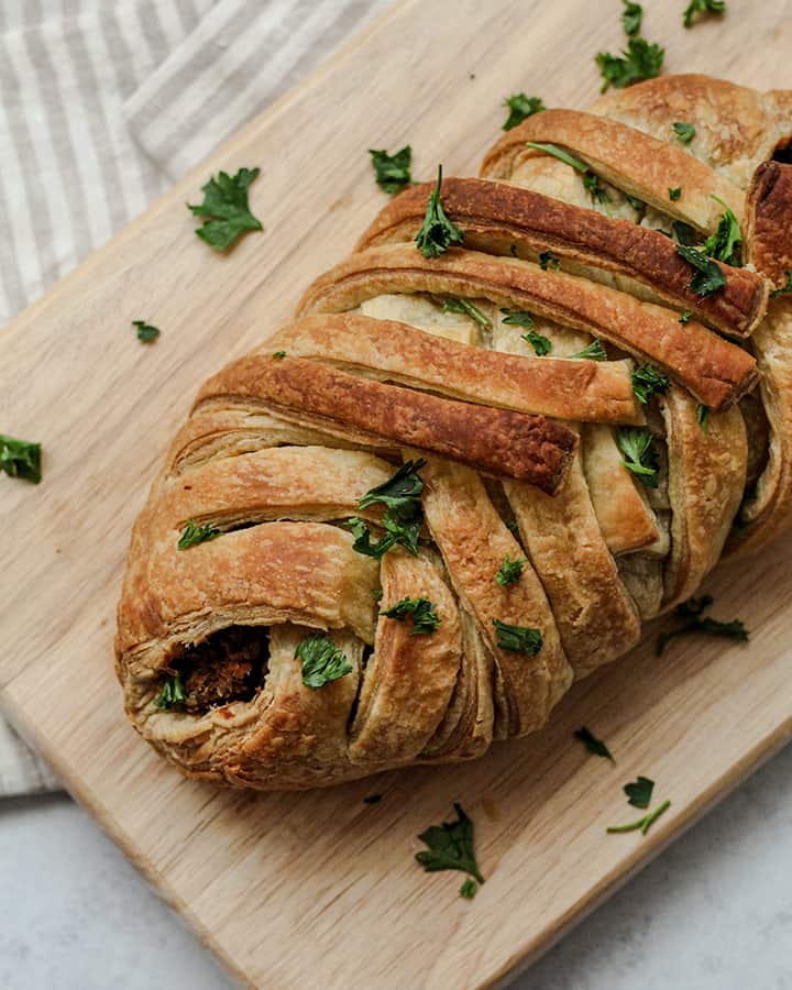 Fully braided wellington straight out of the oven and topped with some minced parsley.