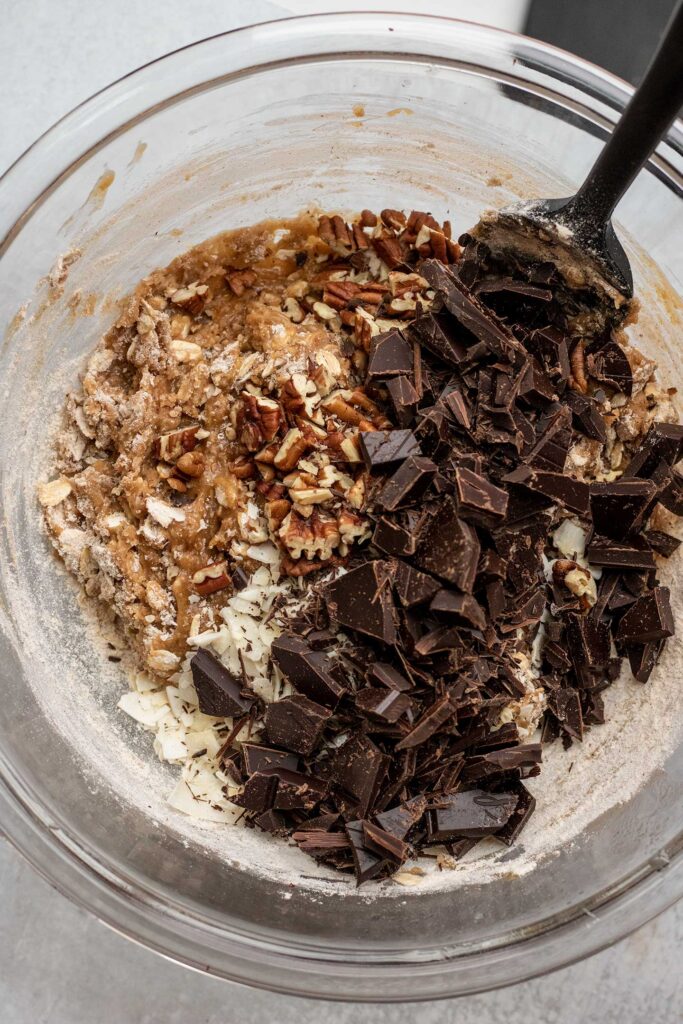 Folding in the chocolate, pecan and coconut mix ins. to the dough.