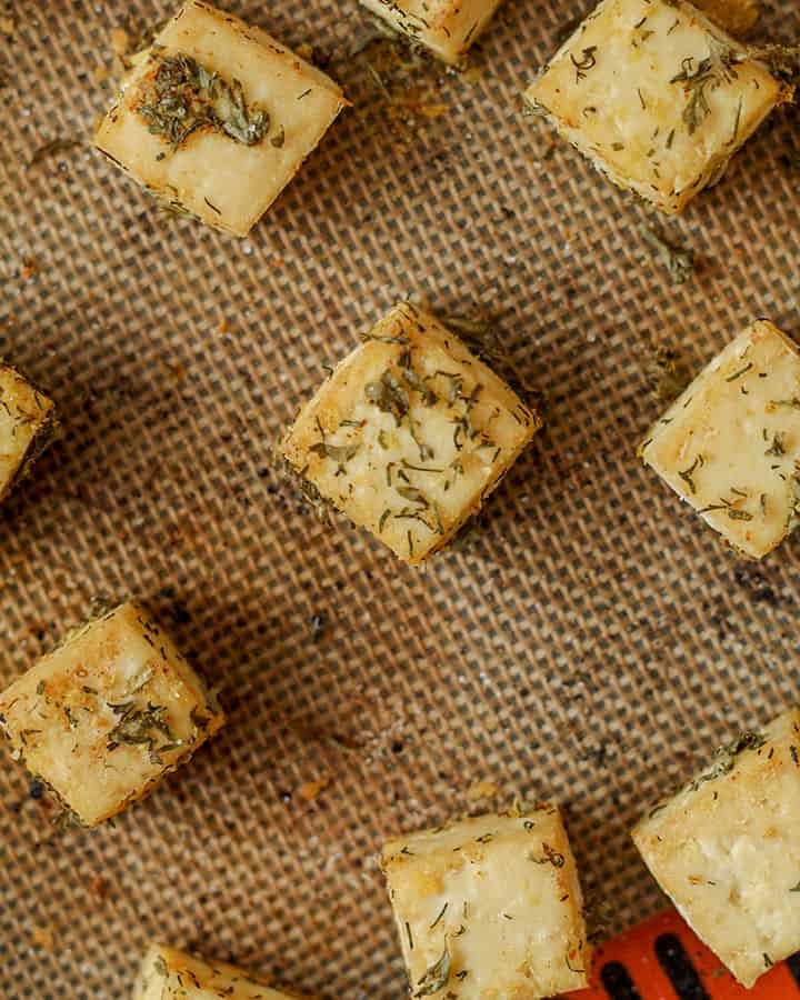 Ranch flavored tofu on a baking silpat, fresh and out of the oven. The tofu is golden and crisp.