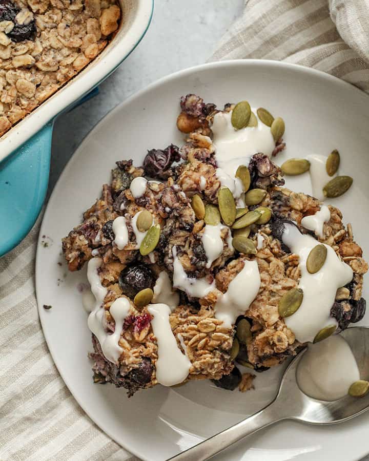 A piece of the baked oatmeal topped with pepitas and plant based yogurt.