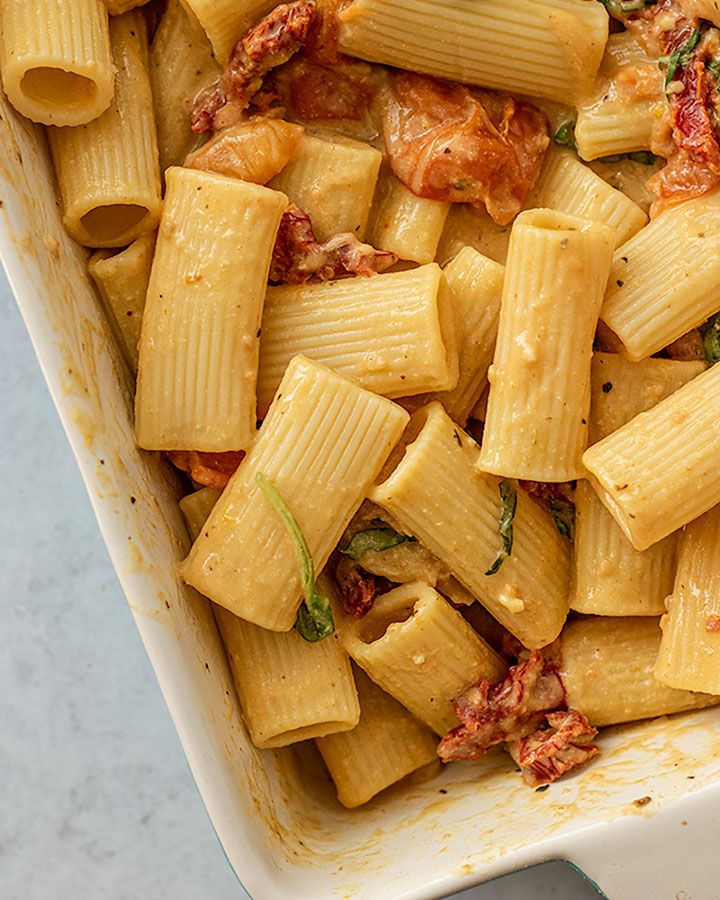 Pasta and fresh basil mixed in with the sauce to coat evenly.