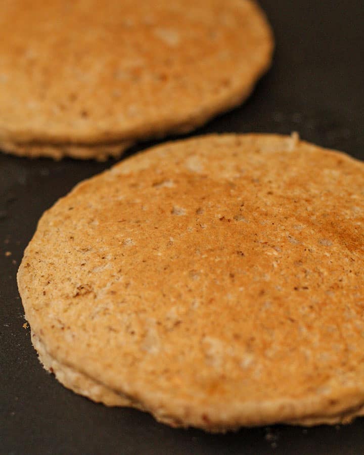 Pancakes cooking on a griddle.