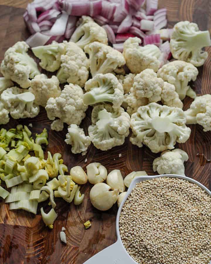 Cutting board with quinoa and chopped cauliflower, onions, garlic and celery.