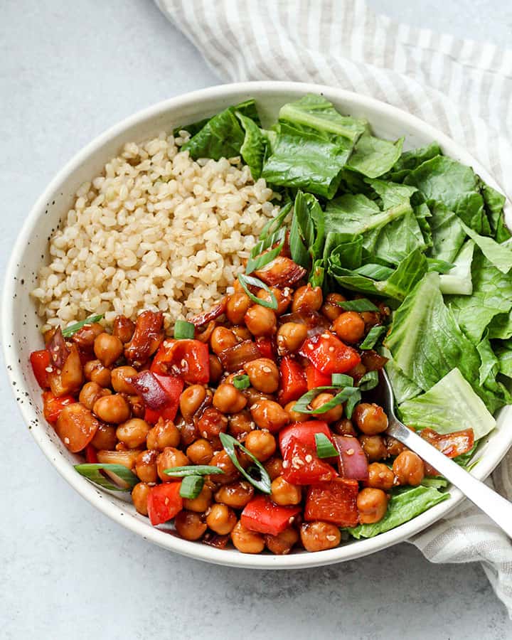 Side view of the garlic chili chickpeas paired with rice and greens.