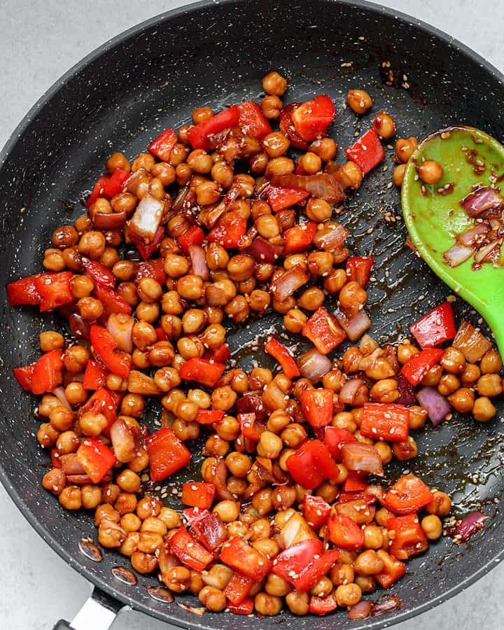 A pan of cooked garlic chili chickpeas being sautéed.