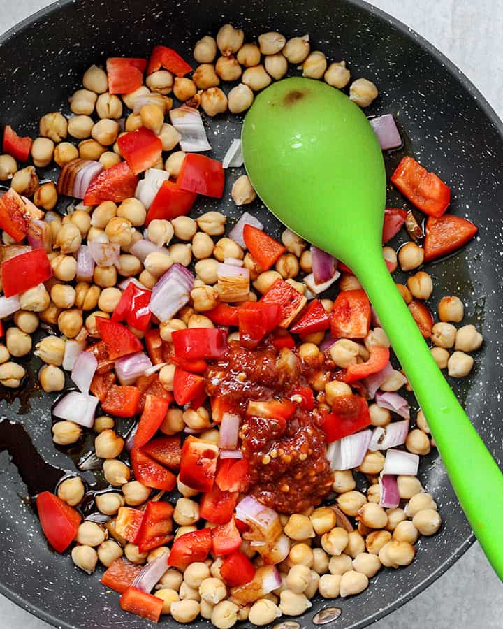 Stirring all of the chickpeas and veggies together with the garlic chili sauce, soy sauce and sweetener.
