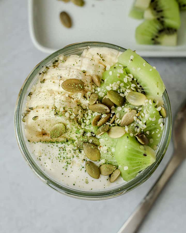 Top view of the oats topped with banana, kiwi, pepitas and hemp hearts.