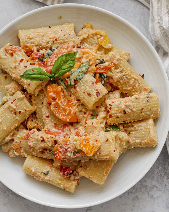 Plate of tofu "feta" pasta topped with fresh basil and red pepper flakes.