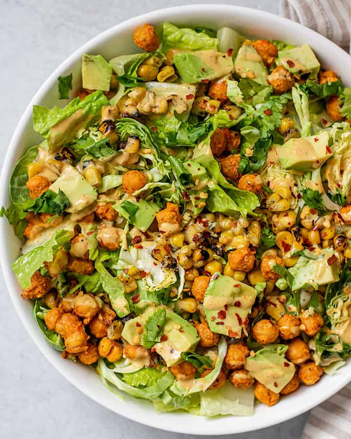 Close up of completed adobo chickpea salad topped with more tahini dressing.