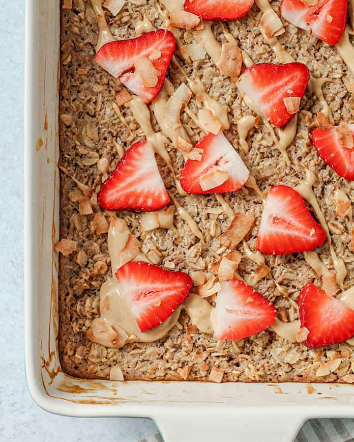 Baked oatmeal decorated with sweet sauce and fresh sliced strawberries.