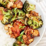 Close up of cashew tofu topped with scallions, red pepper flakes, and sesame seeds.