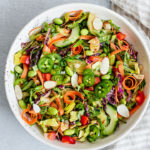 Bowl of colorful salad next to a napkin.