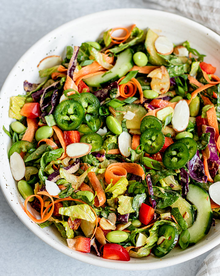 Close up of edamame crunch salad topped with jalapeño slices.