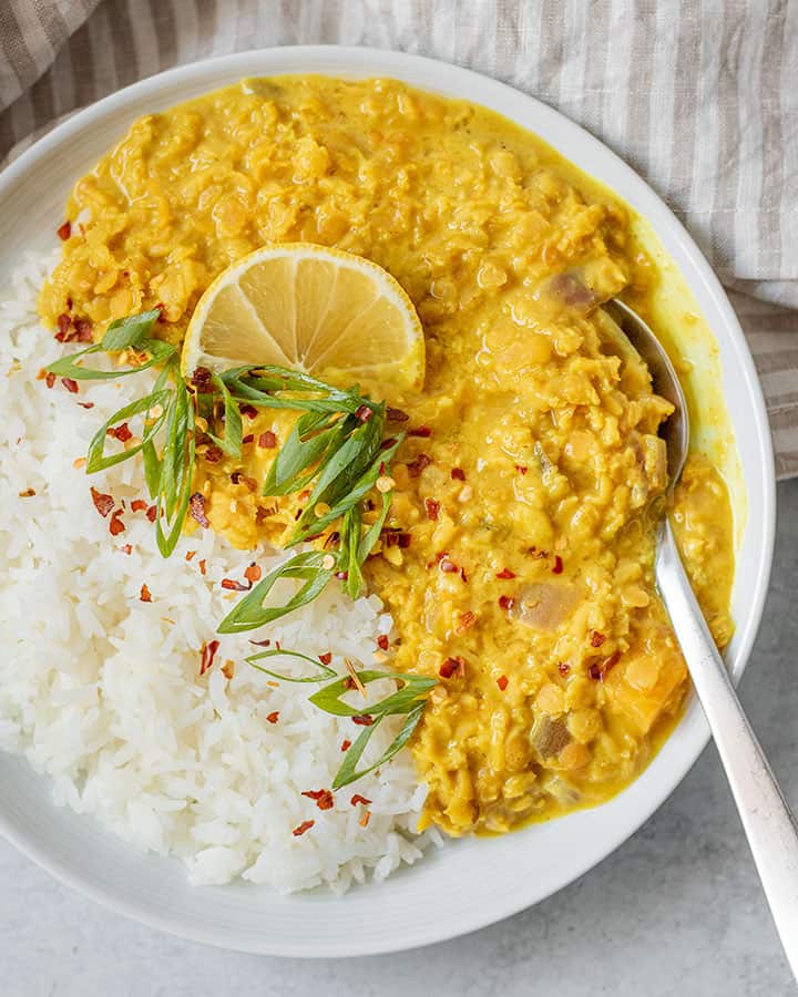 Bowl of rice with curry being spooned up.