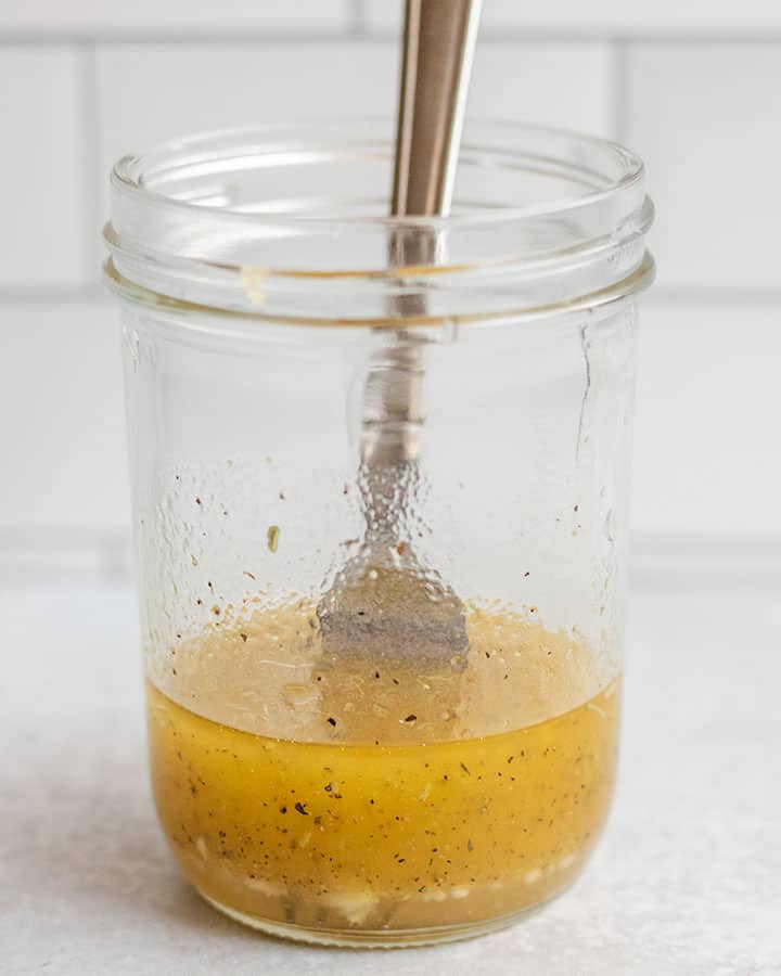 Jar of fully mixed lemon garlic dressing.