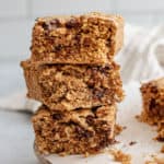 Stack of oatmeal bars with extra oat bars in the background.